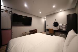 GongjuStay Oneul的一间酒店客房,配有一张白色的床和一张书桌
