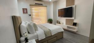 安吉利斯CozyNest - Modern 1 Bedroom Gem Luxury Smart Unit的一间卧室配有一张床和一台平面电视