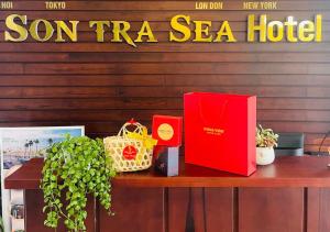 岘港Sontra Sea Hotel的一张桌子,上面有红色的书和其他物品