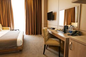 比什凯克City Stay Bishkek的酒店客房配有书桌和床。