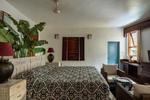 瓦加托瓦加托之家度假村的一间卧室配有一张床和盆栽植物