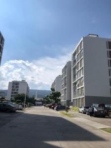 瓜达拉哈拉Departamento de lujo, exclusivo Terraza y jardín gh02的停车场,停车场有汽车停在大楼旁边