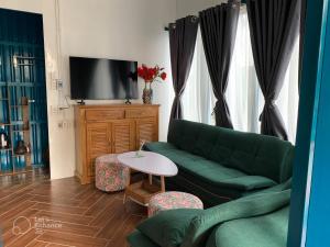 Tây NinhVulunVili Homestay的客厅配有绿色沙发和桌子