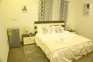 阿克拉3D's Luxury Properties的一间卧室配有一张大床,上面有毛巾
