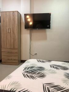 马尼拉JMC Homes的卧室配有一张床铺,墙上配有电视