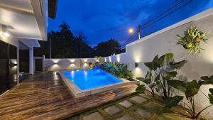 瓜埠Rumah Amaan的后院设有游泳池和木甲板