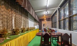 哥印拜陀Itsy By Treebo - Sri Mani'S Residency, Coimbatore Airport的一间在房间内配有桌椅的餐厅