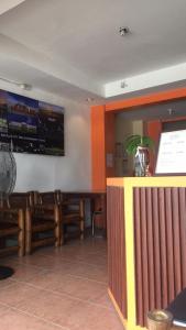 巴科洛德RedDoorz at Rio Bella Lacson St Bacolod的一间带木椅的用餐室和一间酒吧