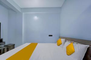 兰奇FabExpress JT Complex的一张带黄色和白色枕头的床