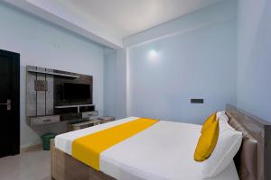 兰奇FabExpress JT Complex的一间卧室配有一张带黄色枕头的床和电视。