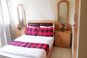 贾夫纳Nallur Mylooran Arangam的一间卧室配有一张带两个红色和黑色枕头的床