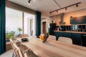 莱比锡Luga Homes - Stadthaus的厨房配有长木桌子和椅子