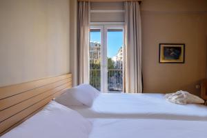 塞萨洛尼基阿斯托利亚酒店的一间卧室设有一张大床和窗户
