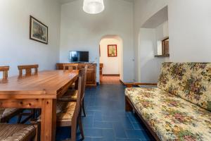 GiannellaOrbetello Giannella Apartment的一间带木桌和沙发的用餐室
