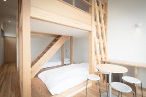 IeuraTeshima ESPOIR PARK的客房设有两张双层床、一张桌子和凳子。