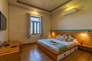 斋浦尔GiriSadan Organic Farm Retreat & Botanical Forest的一间卧室设有一张大床和一个窗户。