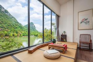 桂林桂林和舍湖畔度假酒店的客房设有大窗户,享有河景