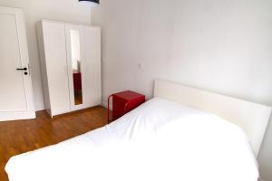斯特拉斯堡Le Gutenberg - Joli T2 dans le Carré d'Or的白色卧室配有白色的床和红色凳子
