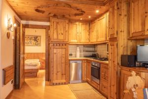 科尔蒂纳丹佩佐Casa Lacedel 2, on ski slopes的厨房配有木制橱柜和炉灶烤箱。