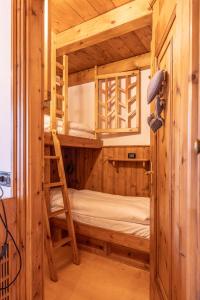 科尔蒂纳丹佩佐Casa Lacedel 2, on ski slopes的木制客房的双层床,配有梯子