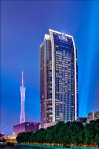 广州广州富力丽思卡尔顿酒店的一座高大的建筑,前面有一座塔