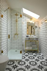菲盖拉-达福什Dona Maria Hotel的带淋浴、盥洗盆和镜子的浴室