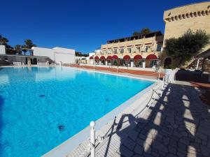 Marina di LeucaMessapia Hotel的大楼前的大型游泳池