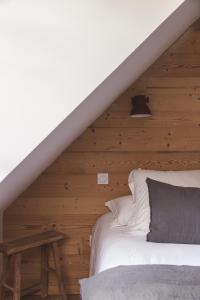 圣拉里苏朗Les Hauts de Saint-Lary的一间卧室设有一张床和木墙