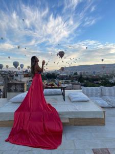 格雷梅Henna Hotel-Adults Only的穿着红色衣服的女人站在屋顶上,身着气球