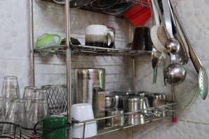 蒂鲁瓦纳马莱Da Mantra House的厨房里的架子,配有玻璃杯和餐具