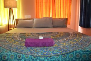 蒂鲁瓦纳马莱Da Mantra House的床上有紫色毯子