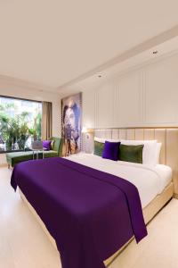孟买Aurika,Mumbai International Airport的一间卧室配有一张带紫色床单的大床