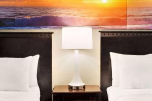 大洋城戴斯海滨酒店的酒店客房设有两张床和一张桌子上的台灯。