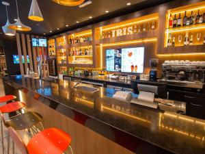 亚松森ibis Asuncion的餐厅的酒吧,有红色凳子