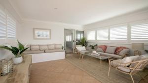 特里格尔Beach Vibes at Terrigal的带沙发和椅子的客厅以及窗户。