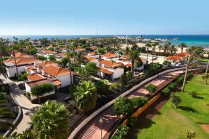 卡勒达德福斯特Barceló Fuerteventura Castillo的享有城市的空中景致,设有房屋和海洋