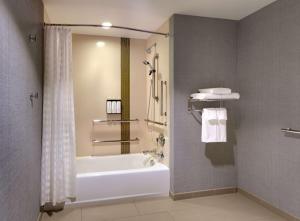 普罗沃Hyatt Place Provo的设有带浴缸和淋浴的浴室。