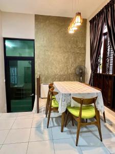 马六甲Rumah Mok Aji Homestay Melaka的一间带桌子和两把椅子的用餐室