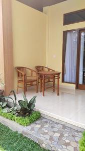 乌布D'Natha Villa Ubud的庭院设有2张长椅和桌子