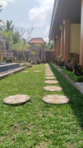 乌布D'Natha Villa Ubud的草上草原上带石头的花园