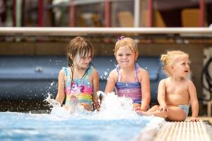巴德瓦尔特斯多夫H2O Hotel-Therme-Resort, für Familien mit Kindern的三个女孩坐在游泳池里