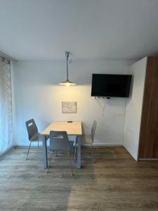 达沃斯Beautiful Cozy Studio Davos的用餐室配有桌椅和平面电视。
