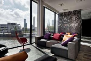鹿特丹Mainport Hotel Rotterdam, a Hilton Affiliate Hotel的带沙发和大窗户的客厅