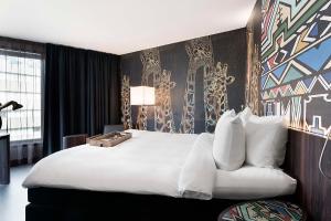 鹿特丹Mainport Hotel Rotterdam, a Hilton Affiliate Hotel的酒店客房设有一张大床和一张沙发。