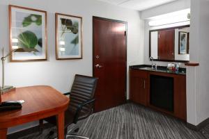 俄克拉何马城俄克拉荷马城机场凯悦酒店的客房设有书桌、桌子、桌子和椅子。