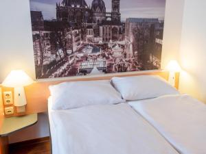 亚琛B&B Hotel Aachen-Hbf的卧室配有一张白色床,墙上挂着一幅画