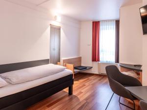 亚琛B&B Hotel Aachen-Hbf的配有床、桌子和椅子的房间