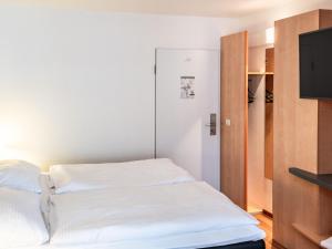 亚琛B&B Hotel Aachen-Hbf的一间卧室配有一张床和一台平面电视