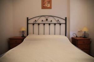 科尼尔-德拉弗龙特拉Apartamento Cadiz Bajo的一间卧室配有一张带2个床头柜的大型白色床