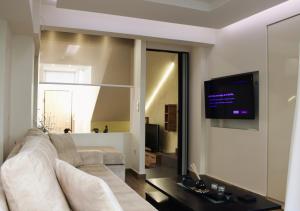 雅典The Ellinikon - Metro Apartment的客厅配有沙发和墙上的电视